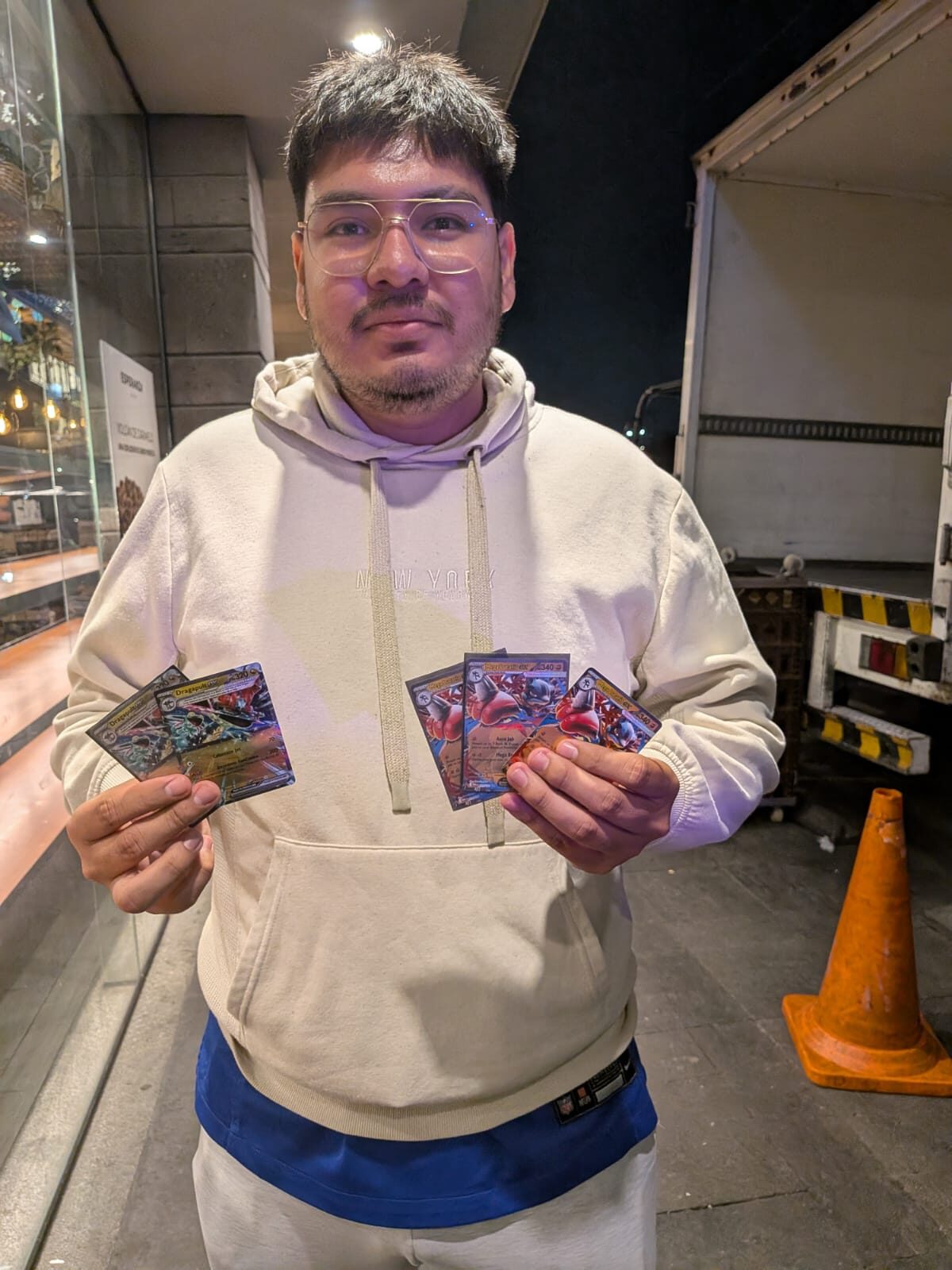 Jugador de Pokémon TCG con cartas Dragapult ex y Charizard ex compradas para la causa