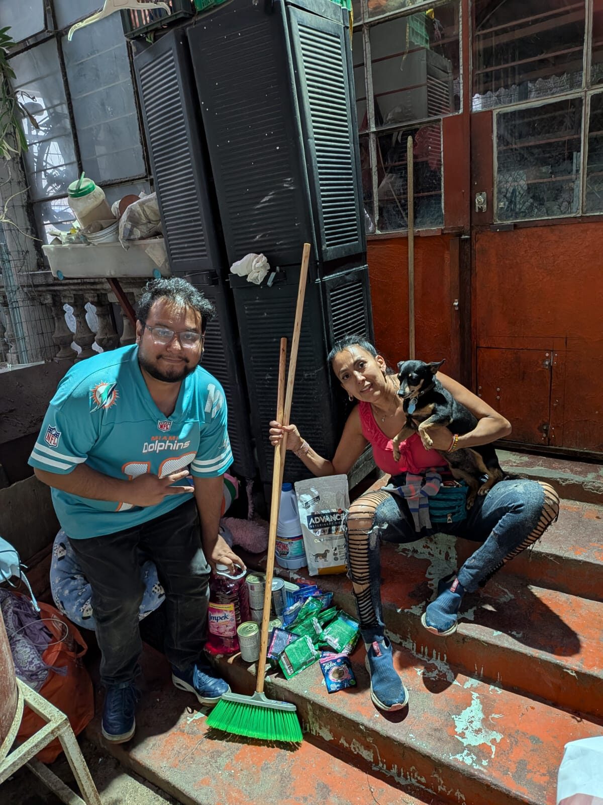 Beto Hernández de Broken Cards entregando productos de limpieza, alimento Advance y medicamentos a Dinah Laureano del Centro de Adopción Pet Mex
